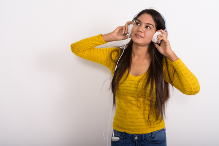 Studio shot of young Indian woman thinking while looking up andの写真素材