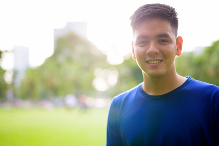 Young handsome Asian man relaxing at the parkの写真素材