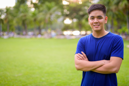 Young handsome Asian man relaxing at the parkの写真素材