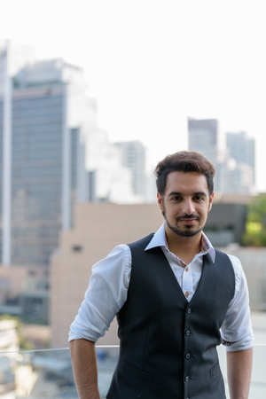 Young handsome Indian man at rooftop in Bangkok Thailandの写真素材