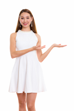 Studio shot of young happy beautiful Asian woman smiling and staの写真素材