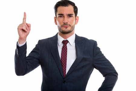 Studio shot of young handsome businessman posing while pointingの写真素材