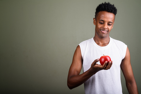 Young handsome African man ready for gym against colored backgroの写真素材