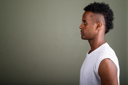 Young handsome African man ready for gym against colored backgroの写真素材