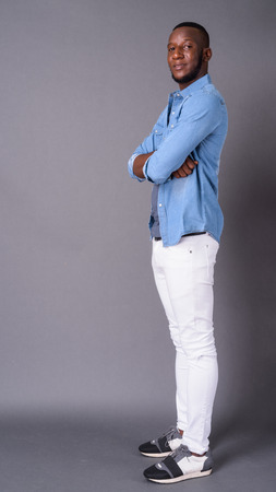 Young handsome African man with short hair against gray backgrouの写真素材