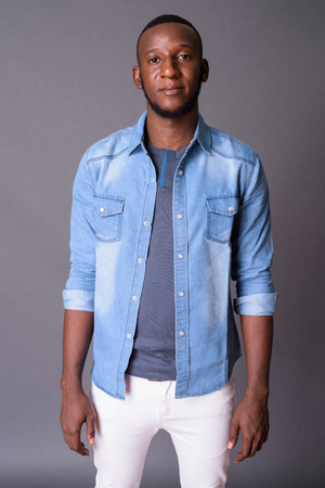 Young handsome African man with short hair against gray backgrouの写真素材