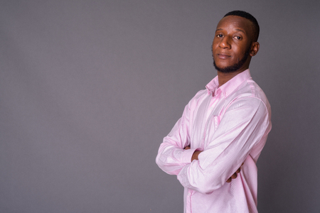 Young handsome African man with short hair against gray backgrouの写真素材