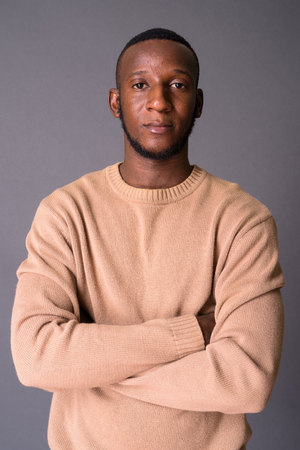 Young handsome African man with short hair against gray backgrouの写真素材