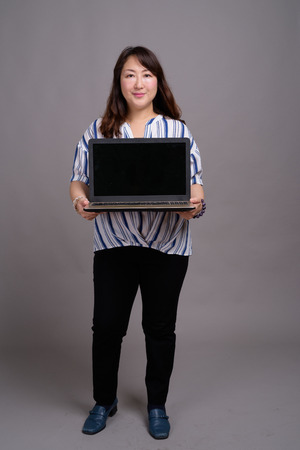 Portrait of Japanese businesswoman holding laptop with copy spaceの写真素材