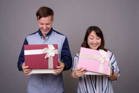 Businessman and mature Asian businesswoman holding gift boxの写真素材