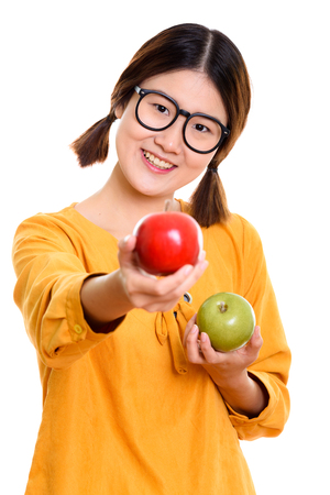 Young happy Asian woman smiling while holding green apple and giの写真素材