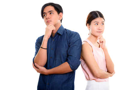 Young Asian couple thinking and looking upの写真素材