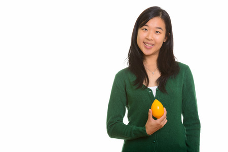Portrait of young happy Asian woman holding lemonの写真素材