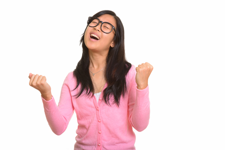 Young happy Asian woman looking excited with arms raisedの写真素材