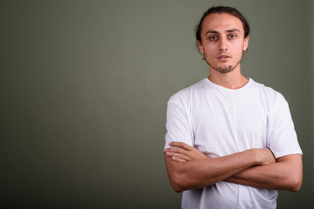 Young handsome man wearing white shirt against colored backgroun
