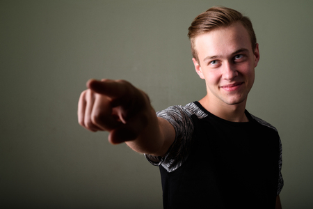 Young handsome man with blond hair against colored backgroundの写真素材
