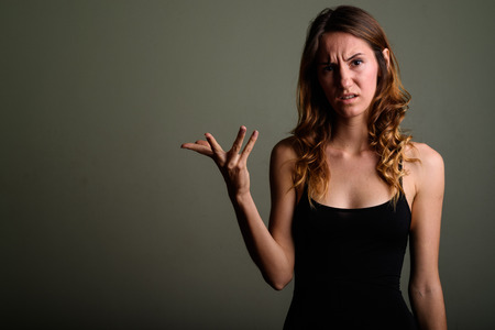 Young beautiful woman wearing sleeveless top against colored bacの写真素材