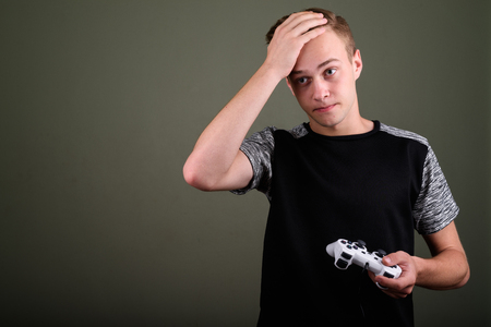 Young handsome man with blond hair against colored background