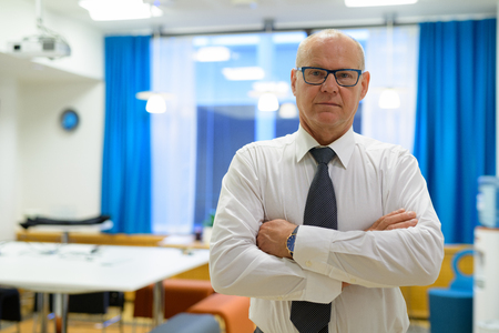 Handsome Senior Businessman With Arms Crossed In The Officeの写真素材