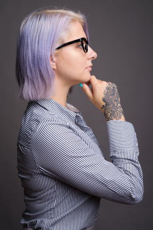 Profile view of businesswoman with short colorful hair thinkingの写真素材