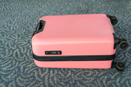 Portrait Of Pink Trolley Luggage Suitable For Light Travels Lying On Carpet Floor