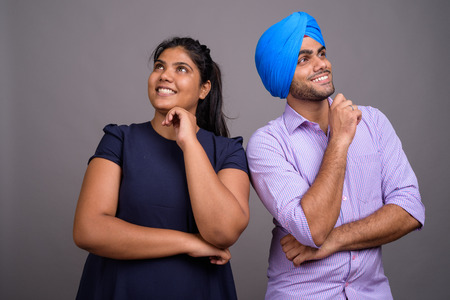 Young happy Indian couple together thinking and looking upの写真素材