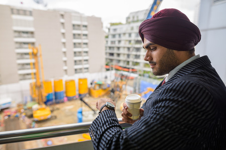 Indian businessman looking at construction development site with skyscrapersの写真素材