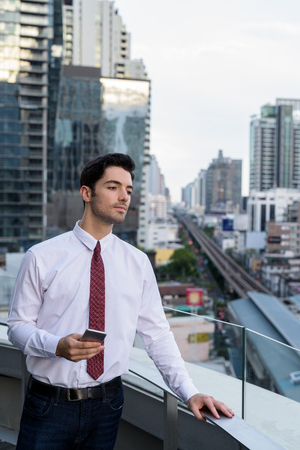 Portrait of young handsome businessman in cityの写真素材