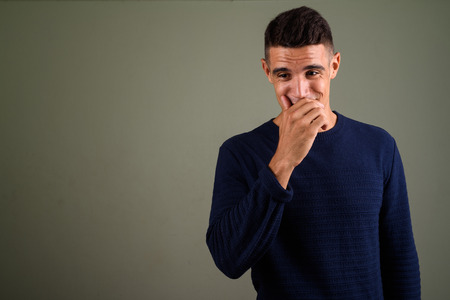 Young handsome man wearing sweater against colored backgroundの写真素材