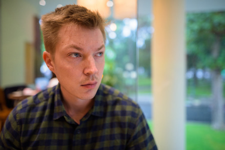 Young handsome tourist man sitting and thinkingの写真素材