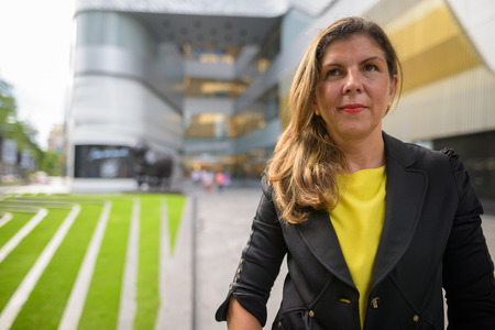 Portrait of mature businesswoman thinking and planning outdoorsの写真素材