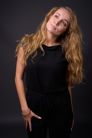 Young beautiful businesswoman with long wavy blond hair againstの写真素材