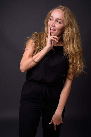 Young beautiful businesswoman with long wavy blond hair againstの写真素材