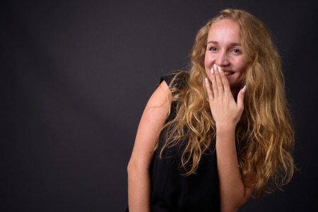 Young beautiful businesswoman with long wavy blond hair laughingの写真素材