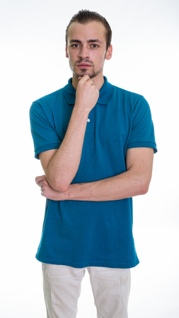 Studio shot of young bearded man standing while thinking againstの写真素材