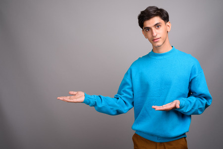 Young handsome Persian teenage boy showing copyspace