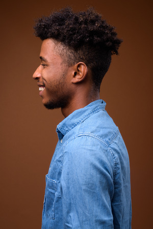 Profile view portrait of young handsome African man smilingの写真素材