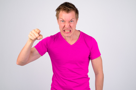 Angry young man looking aggressive and pointing to cameraの写真素材