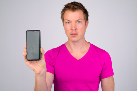 Face of young handsome man showing phoneの写真素材