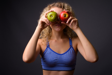 Young beautiful sport woman ready for gym holding healthy appleの写真素材