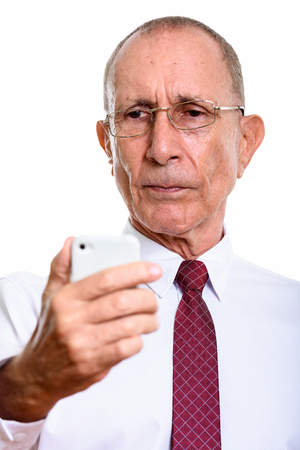Face of senior businessman holding mobile phoneの写真素材