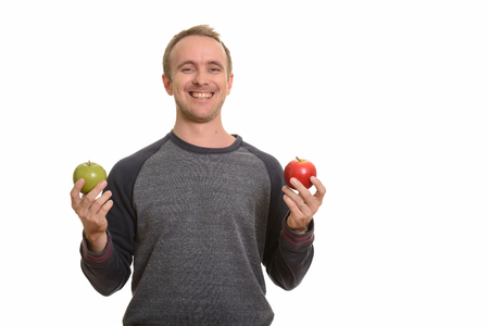Happy Caucasian man holding red and green appleの写真素材