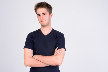 Young handsome man with arms crossed against white backgroundの写真素材