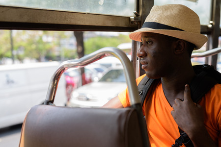 Profile view of young black African tourist man in busの写真素材