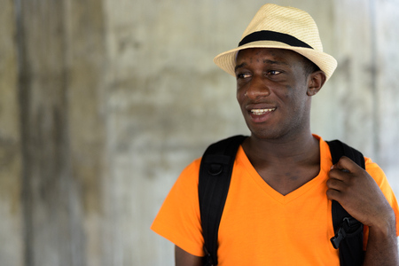 Face of young African tourist man smiling and thinkingの写真素材