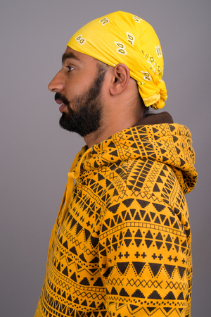 Profile view of young handsome Indian man wearing hoodieの写真素材