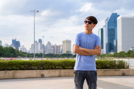 Young Asian teenage boy wearing sunglasses while relaxing at theの写真素材