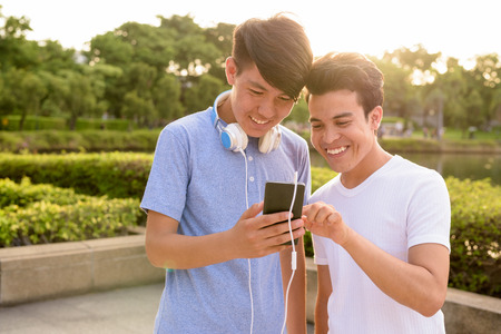 Young Asian man and young Asian teenage boy at the park togetherの写真素材