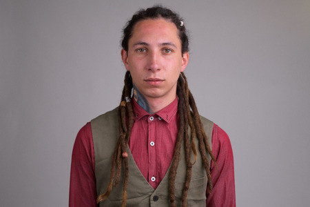 Face of young handsome businessman with dreadlocks