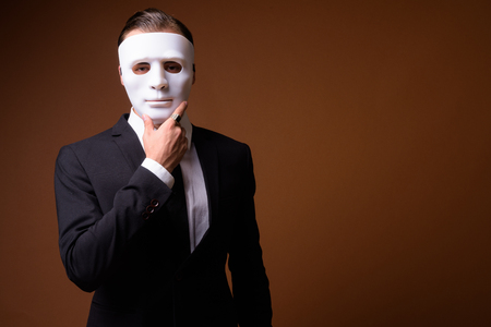 Portrait of young Caucasian businessman wearing white maskの写真素材